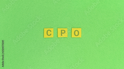 Foto Three yellow square letter tiles spelling out the acronym 'CPO' on a vibrant gre