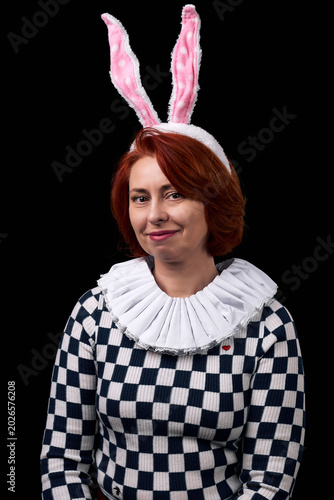 Smiling red-haired woman wearing bunny ears and ruffled collar costume