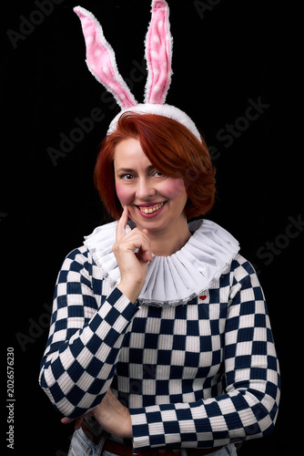 Smiling red-haired woman wearing bunny ears and ruffled collar costume