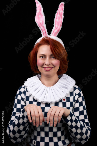 Smiling woman wearing bunny ears posing playfully with rabbit hand gesture