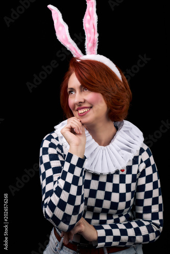 Smiling red-haired woman wearing bunny ears and ruffled collar costume