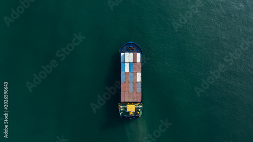 Aerial drone view of cargo container ship sailing in the sea towards the port.