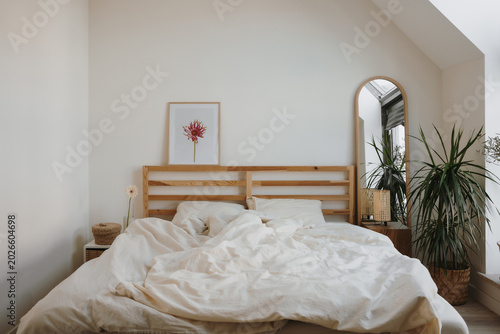 Modern Bedroom With Unmade Bed And Natural Sunlight From Skylight