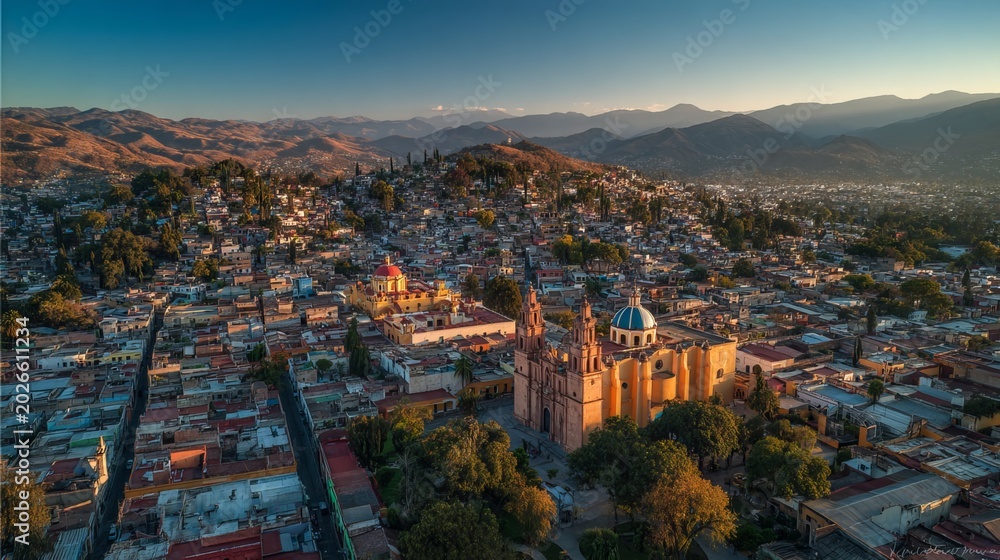 Obraz premium Aerial panoramic view of Oaxaca City colonial rooftops and cathedral domes at sunrise, warm golden light, wide drone view, Mexico outdoor cityscape