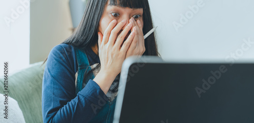 Foto Shocked young woman reacting to unexpected news while using laptop at home, expr
