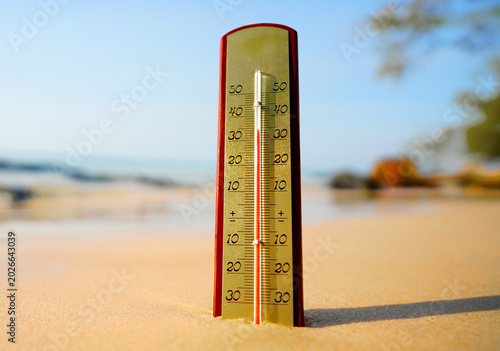 Thermometer on sunset sea beach in tropical. Extremely hot day. Thermometer measuring air temperature. Heat wave weather. Hot weather, drought. Abnormally temperature, extreme heat in Europe. Sunburn.