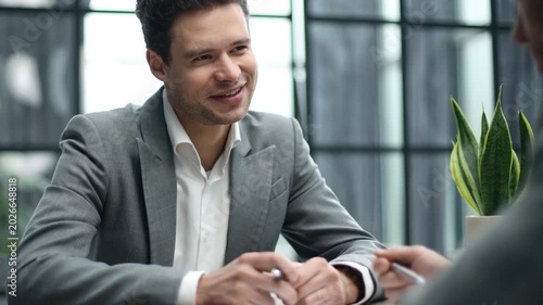 Businessman sits at desk, engaged in serious meeting