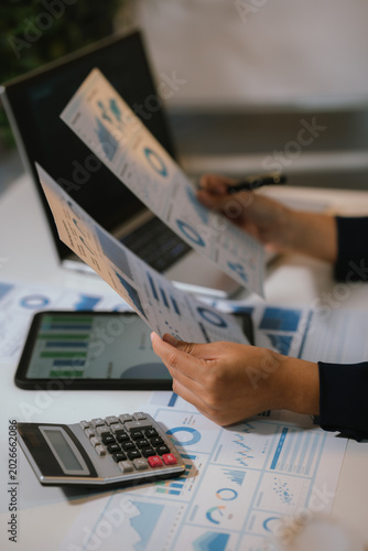 Business analyst reviewing financial data on tablet with charts and calculator, representing digital analytics, budgeting, and corporate finance management.