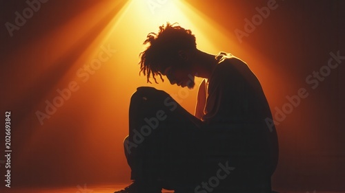 Young person sitting on floor feeling sad and depressed, suffering from mental health loneliness issues