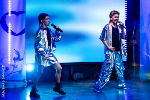 Cuadro en lienzo Girl and boy singer performing with microphone on stage