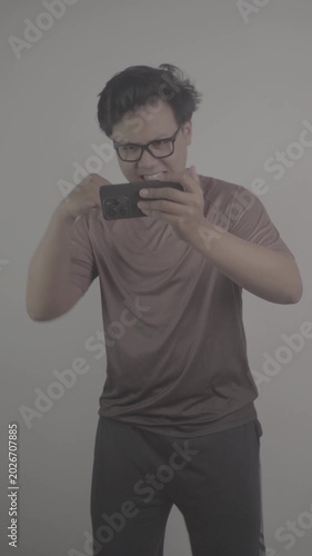 Southeast Asian person watch football on their mobile phones, then rejoice when their team scores goal S-Log3, S-Gamut3.Cine