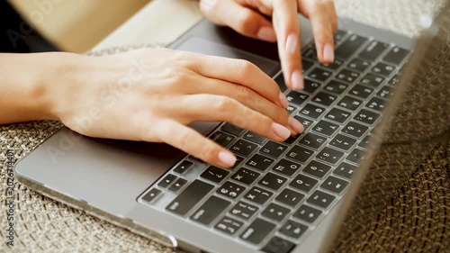 Hands typing on a gray laptop keyboard with a clear silicone cover indoors