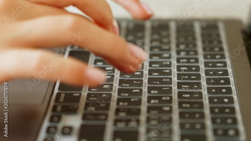 Fingers typing on laptop keyboard with protective cover and Cyrillic letters