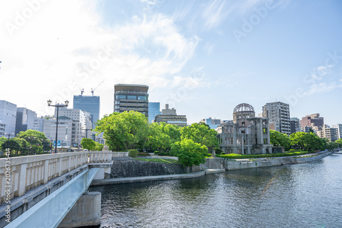 Foto Atomic Bomb Dome Against Blue Sky with Green Trees and Copy Space
