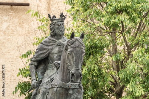 Tableau sur toile Bronze equestrian statue of King Alfonso VIII of Castile framed by green tree le