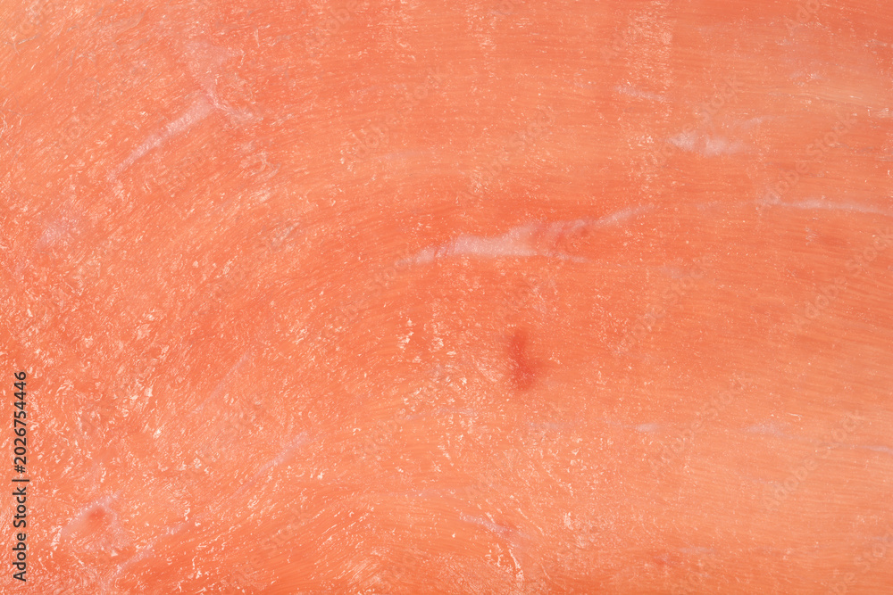 Fototapeta premium Full frame macro view of a pink raw cured ham slice showing smooth surface texture and meat details.