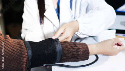 A doctor's hands carefully taking a patient's blood pressure using a sphygmomanometer.