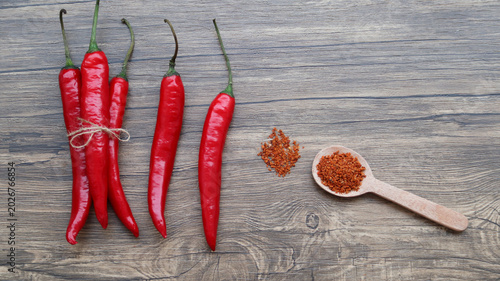 Tablou pe pânză Chilli flakes and fresh peppers on wooden background