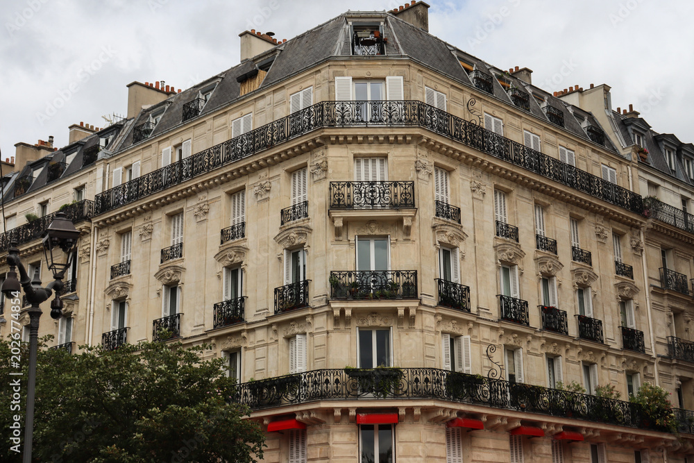 Fototapeta premium Low-angle view of elegant Parisian apartment buildings, showcasing ornate balconies 