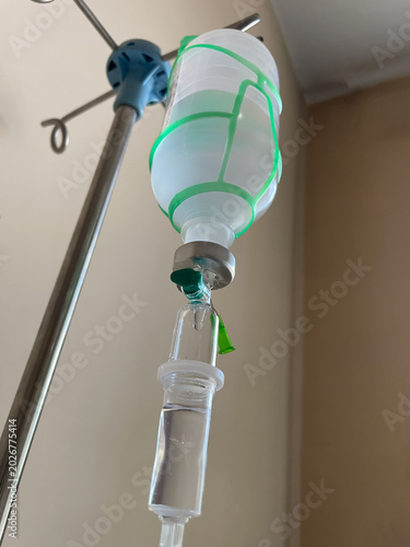 medical close up of iv infusion bottle and drip chamber in clinical ward, oncology treatment equipment illustrating chemotherapy support, cancer care and intravenous medication