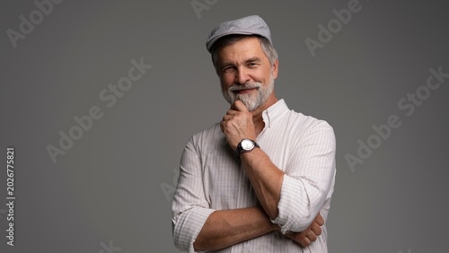 Принти на полотні Smiling man wearing white shirt and flat cap, close-up