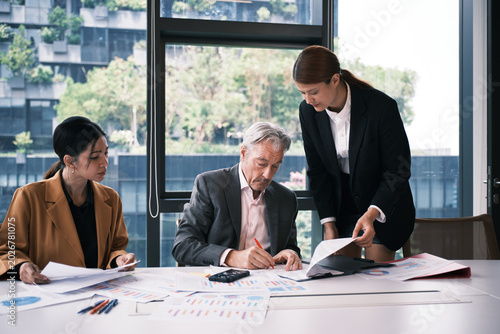 Bild auf Leinwand White senior male CEO seriously works in boardroom, signs business contract documents from female secretary, corporate financial report, and investment project, and executive leadership president
