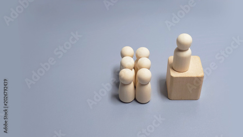 Canvastavla Wooden leader figure standing on elevated block beside team on grey background s