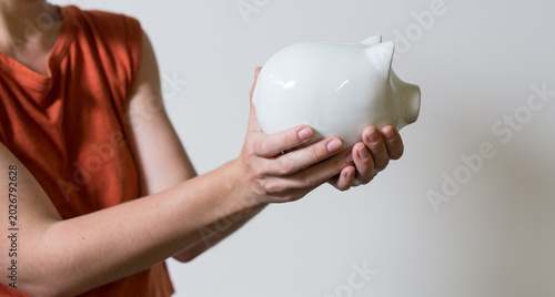 Hands hold a white piggy ba...