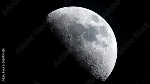 View of the moon surface with visible craters against a deep black space background.