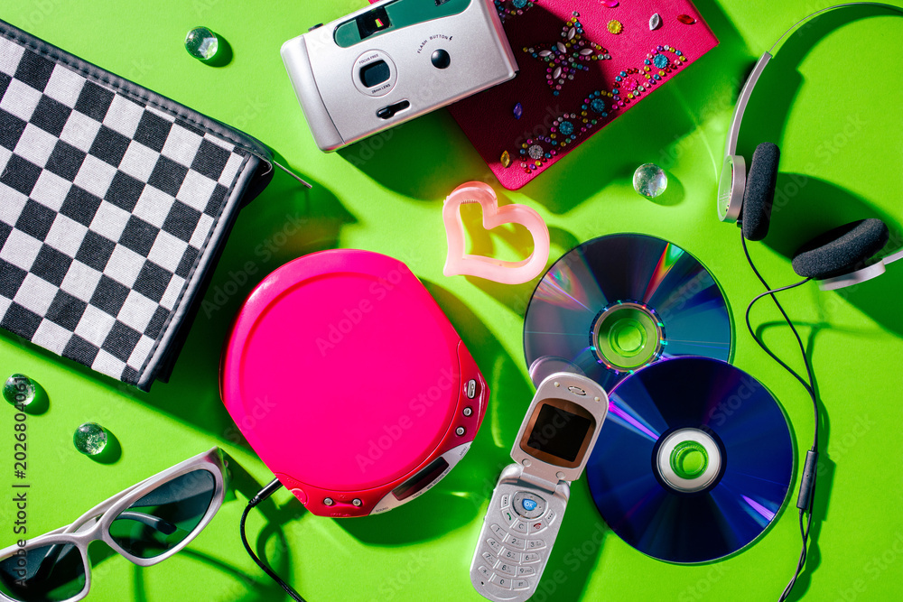 Naklejka premium Vintage 2000s technology flat lay with flip phone camera and CD player