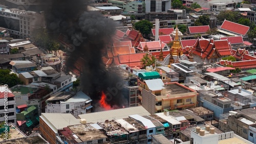 Foto Fire spreading in a dense bangkok urban area near wat traimit temple