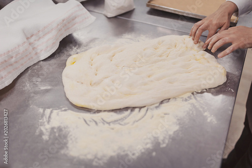 Making focaccia dough in an Italian kitchen with olive oil and flour on the table