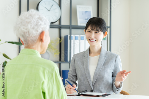 シニアの女性に説明するビジネスウーマン