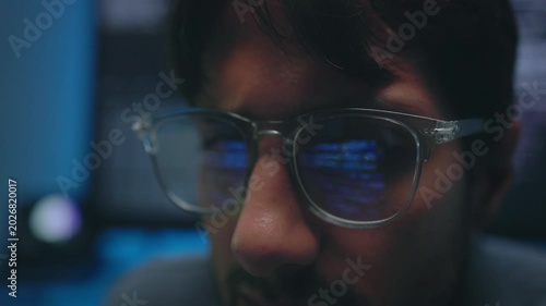 Programmer Analyzing Complex Blue Source Code with Glasses Reflection