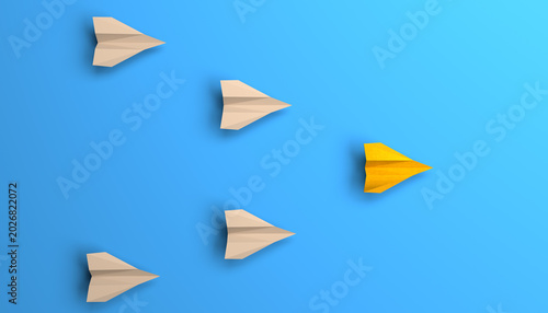 Fotografie Yellow paper plane leading a group of white paper airplanes on a clean blue background