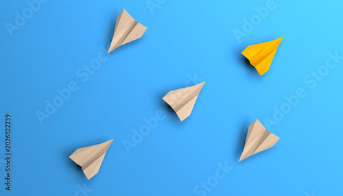 Fotografía Top view of a bright yellow paper airplane flying in a different direction from a group of white origami planes