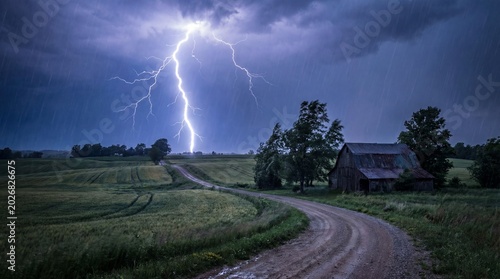 Light and sound energize scenes with lightning strikes concept. A dramatic lightning storm over a rural landscape with a barn.
