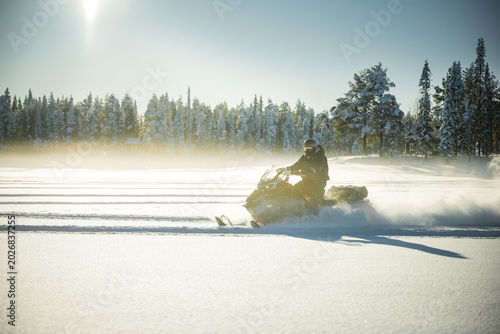 Shot of person riding snowmobile on bright sunny day
