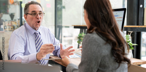 Konstfotografi Senior businessman explaining or complaining to female colleague in office meeti