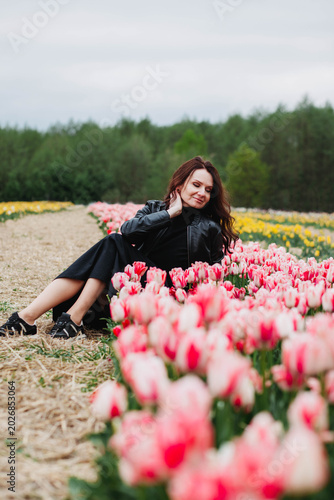 A young woman in a field of tulips. 
