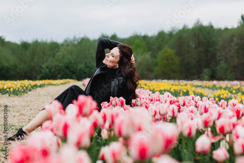 A young woman in a field of tulips. 