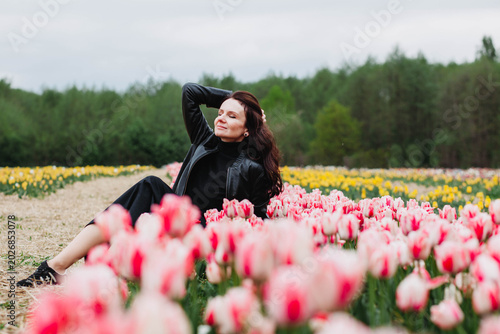 A young woman in a field of tulips. 