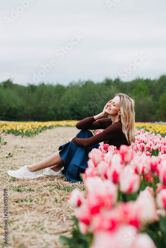 A young woman in a field of tulips. 