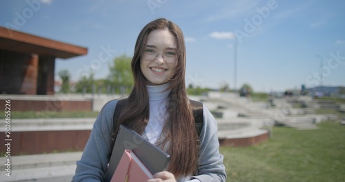 Foto A hand-held portrait of a young female student in casual clothes, wearing glasse
