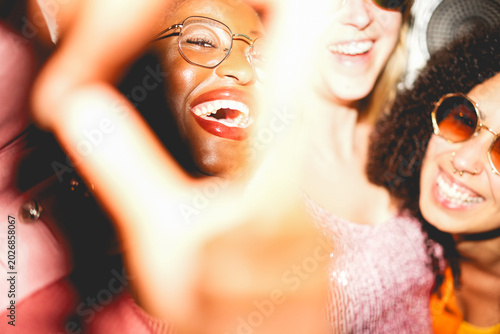 Foto Crazy women friends having fun at night time listening music outdoor and taking