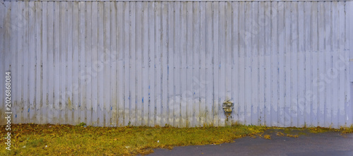 Foto Abandoned urban lot featuring corroded metal fence and weathered natural element
