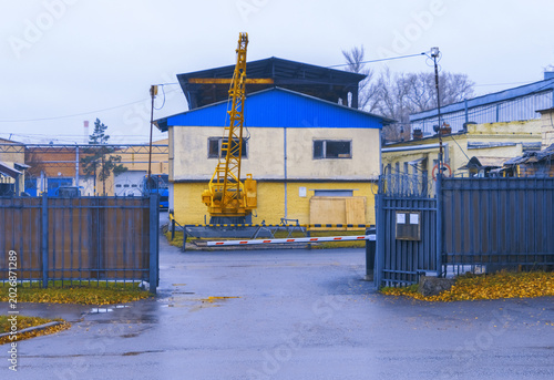 Bild auf Leinwand Industrial activity underway with crane and heavy equipment beside yellow struct