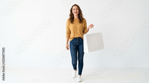 Young woman holding white shopping bag.