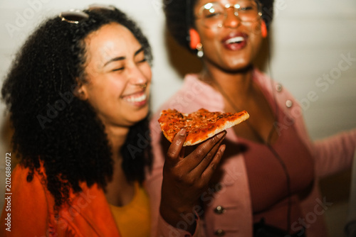 Canvas Print African american girls eating pizza outdoor in the streets after party concert -