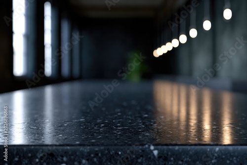 Close-up of a textured dark countertop with a row of lights reflecting